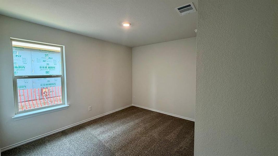 Carpeted interior space featuring neutral wall paint, white baseboards, and a single window with white trim