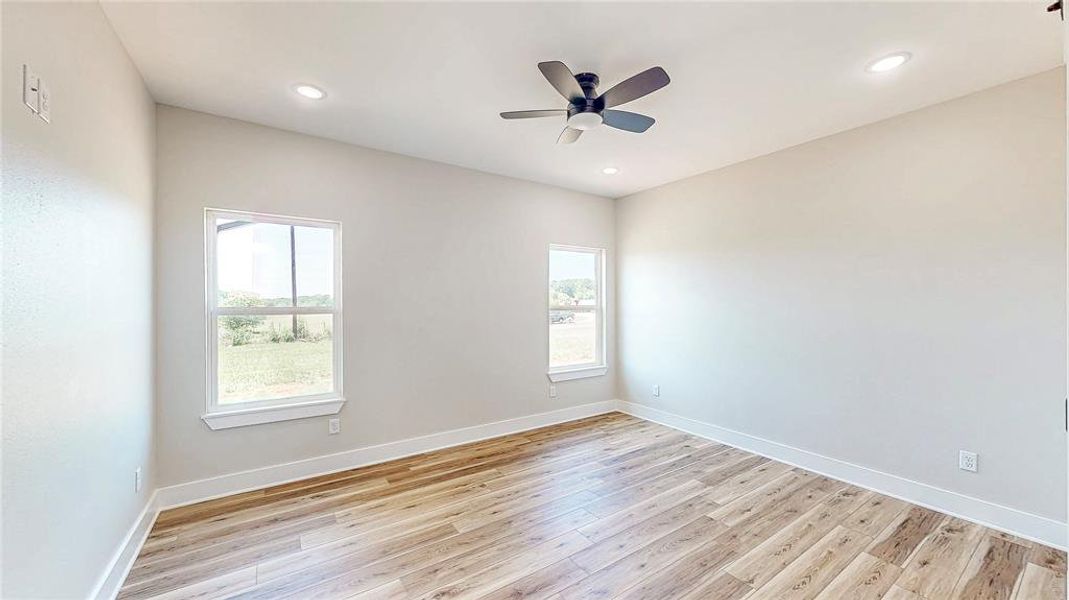 Empty room with healthy amount of natural light, light wood-type flooring, ceiling fan, and recessed lighting Empty room with healthy amount of natural light, light wood-type flooring, ceiling fan, and recessed lighting