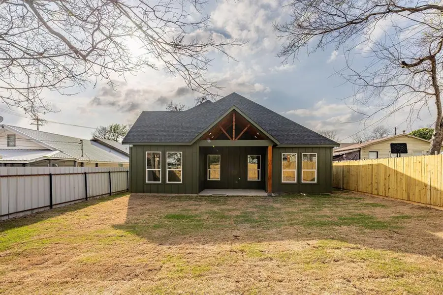 Rear view of property featuring board and batten siding, a patio, a fenced backyard, and roof with shingles