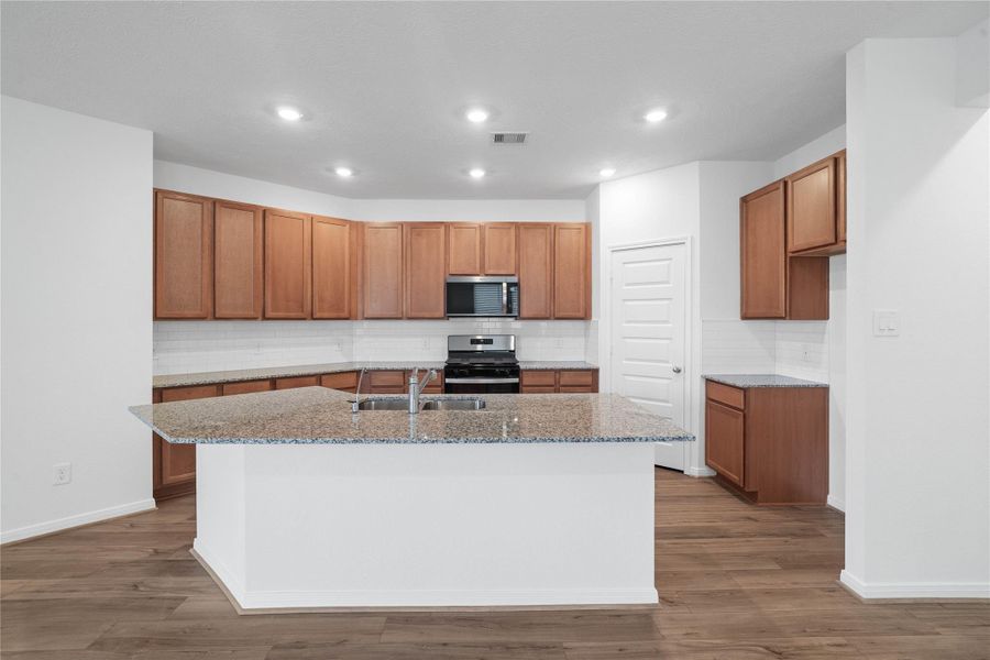 Featuring an extended bar top, the kitchen island provides versatile space for additional seating, meal prep, or entertaining guests. Featuring an extended bar top, the kitchen island provides versatile space for additional seating, meal prep, or entertaining guests.