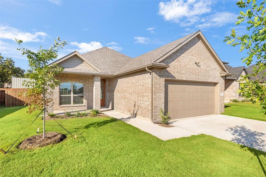 Ranch-style home featuring concrete driveway, roof with shingles, brick siding, and a garage