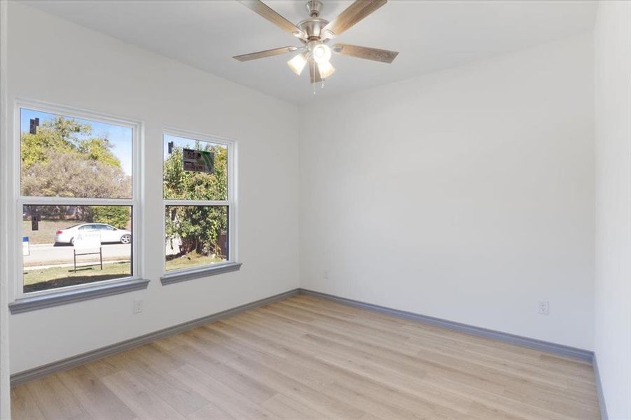 Unfurnished room featuring ceiling fan, a healthy amount of sunlight, and light hardwood / wood-style floors