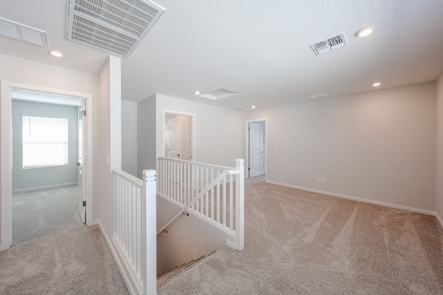 A hallway with white railings.