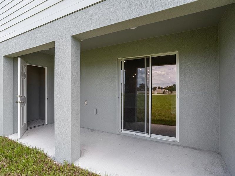 Your interior opens to outdoor living space on a covered lanai with a storage closet - Aruba townhome by Highland Homes