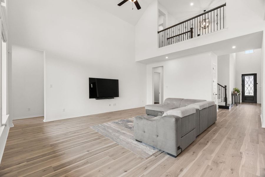 A grand living space with soaring ceilings, a second-story overlook, and warm wood flooring. A grand living space with soaring ceilings, a second-story overlook, and warm wood flooring.