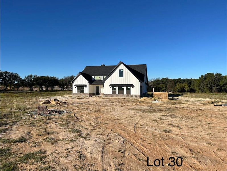 View of front of property featuring board and batten siding and a view of rural / pastoral area View of front of property featuring board and batten siding and a view of rural / pastoral area