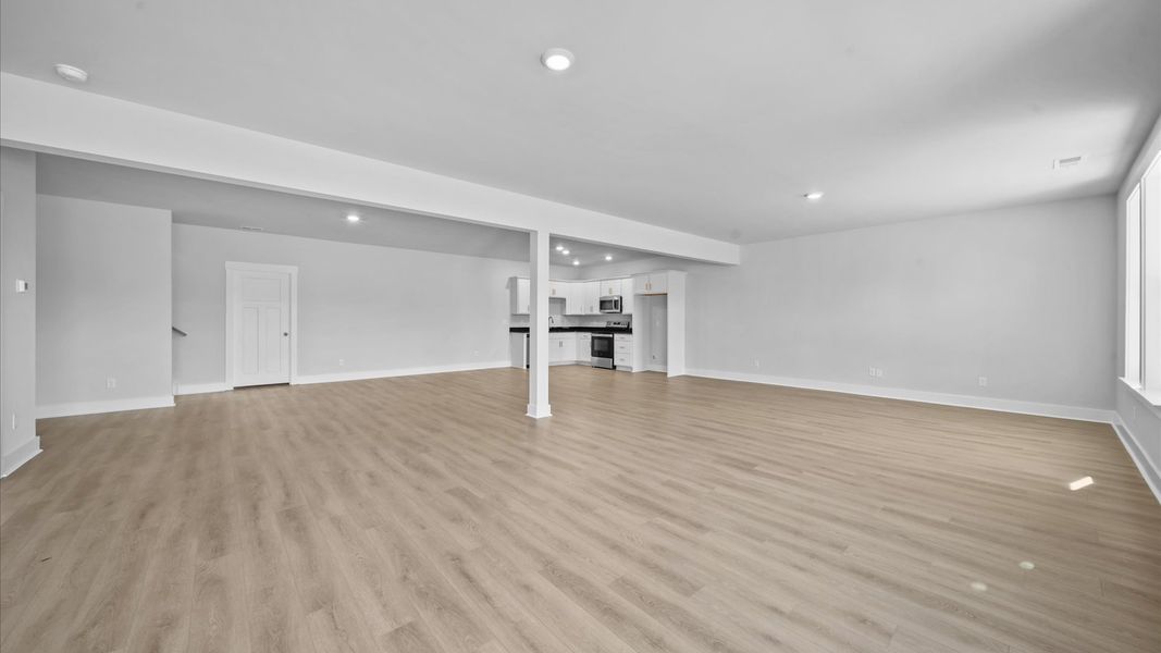 Memorable moments begin in this elegant, open basement with hardwood flooring and refined finishes
