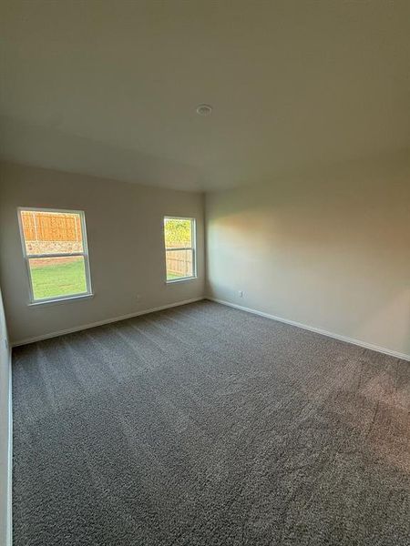 Carpeted spare room featuring baseboards Carpeted spare room featuring baseboards