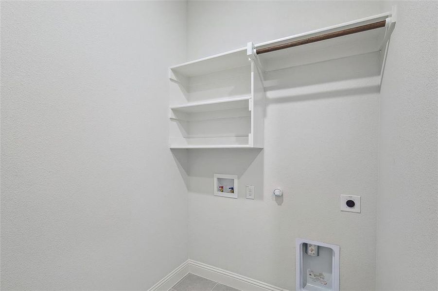 Clothes washing area with hookup for a washing machine, hookup for a gas dryer, tile patterned floors, and electric dryer hookup