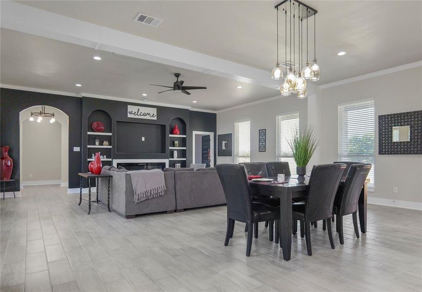 Dining area featuring a chandelier, a ceiling fan, ornamental molding, light wood-type flooring, and recessed lighting