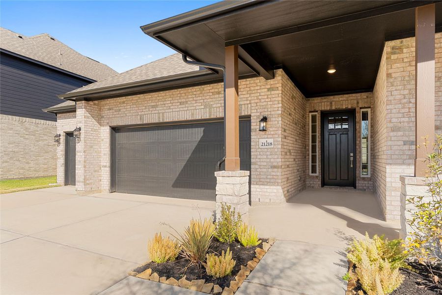 Step closer and admire the inviting covered front porch and handsome entryway, accented by rich brick detailing and architectural depth, a perfect spot to greet visitors or enjoy a quiet moment, all while appreciating the quality craftsmanship and thoughtful design throughout the exterior.
