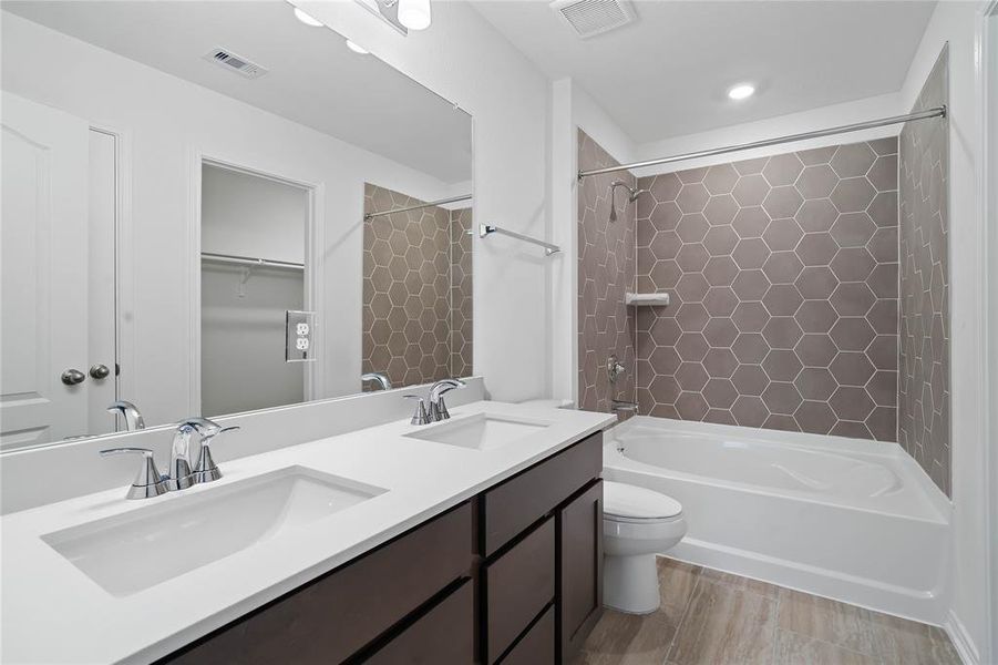 This primary bathroom is definitely move-in ready! Featuring a tub/shower combo, stained cabinets with light countertops, high ceilings, custom paint, sleek and dark modern finishes.