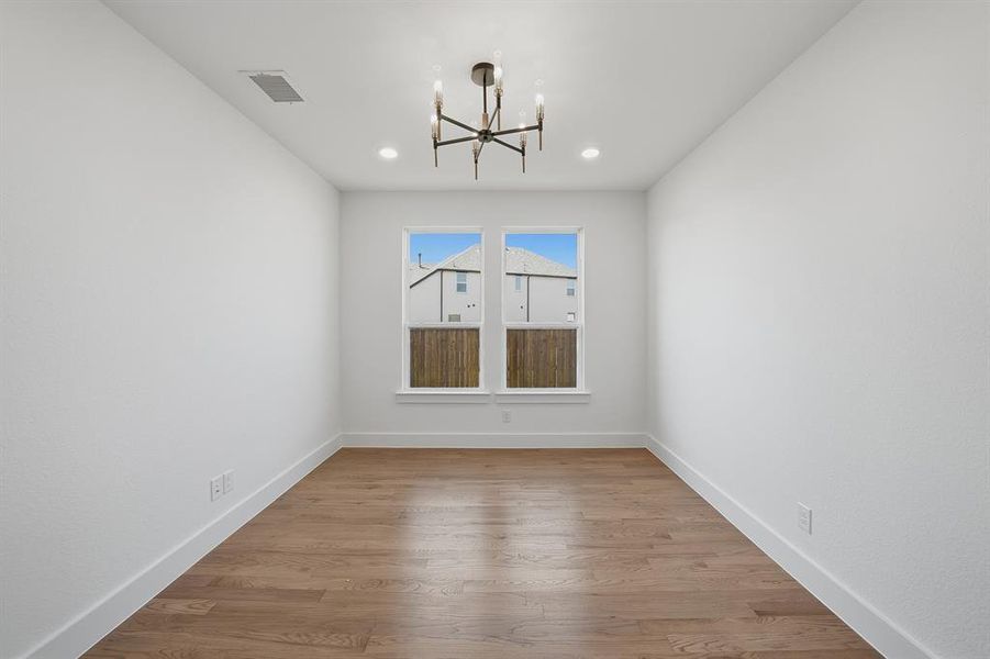 Unfurnished dining area featuring light wood-style flooring, a chandelier, and recessed lighting Unfurnished dining area featuring light wood-style flooring, a chandelier, and recessed lighting
