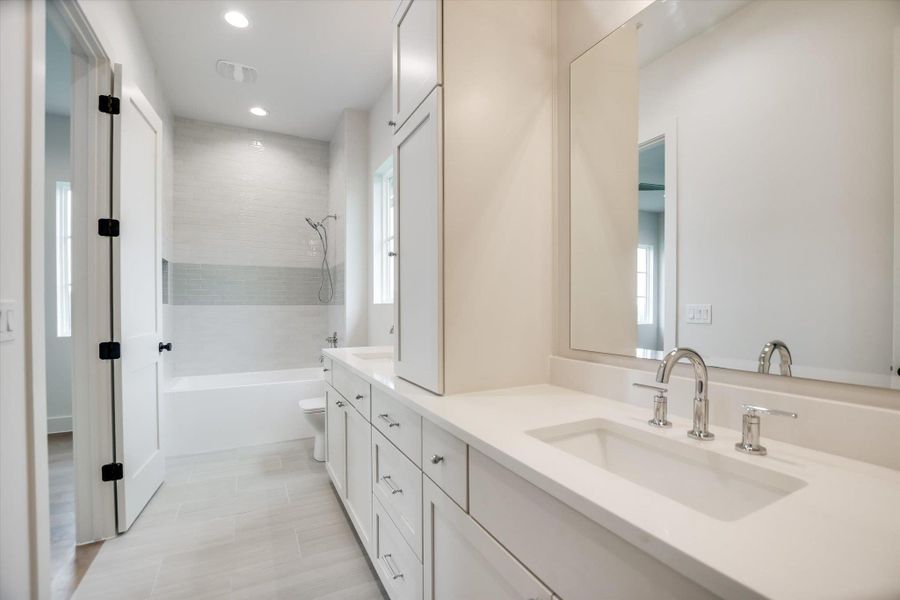 Bathroom featuring a single vanity with an integrated rectangular sink, chrome fixtures, and a large wall-mounted mirror