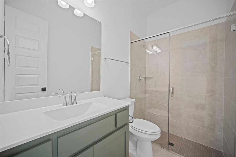 Bathroom featuring an enclosed shower, toilet, and vanity