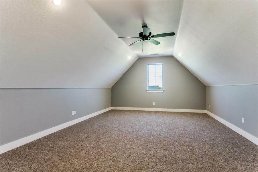Additional living space featuring carpet flooring, lofted ceiling, and ceiling fan Additional living space featuring carpet flooring, lofted ceiling, and ceiling fan