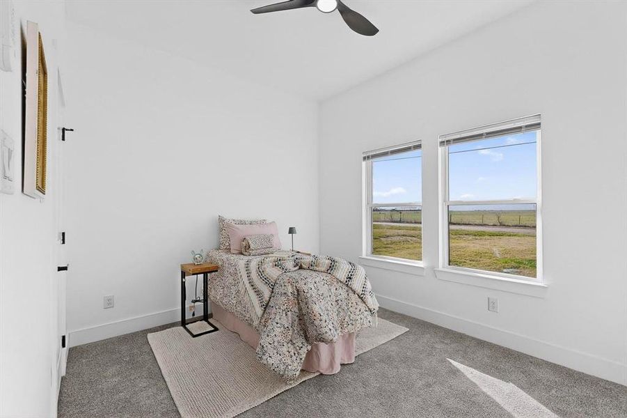 Carpeted bedroom featuring baseboards and a ceiling fan