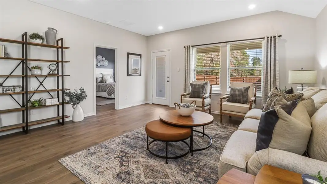 Living area with dark wood-type flooring and recessed lighting