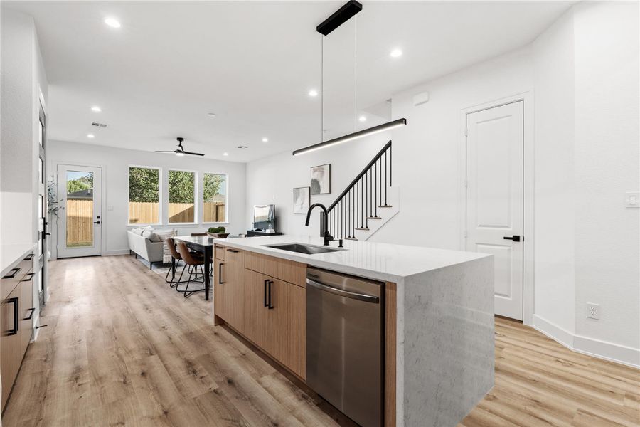 A seamless blend of form and function—this open layout connects kitchen, dining, and living spaces with effortless flow. Oak-colored flooring grounds the space, while clean lines, matte black accents, and Nima Homes’ signature craftsmanship create an atmosphere of understated sophistication.