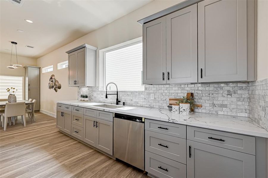 Another angle of this modern kitchen. The open layout flows into a cozy dining area with ample natural light, perfect for entertaining or family meals.