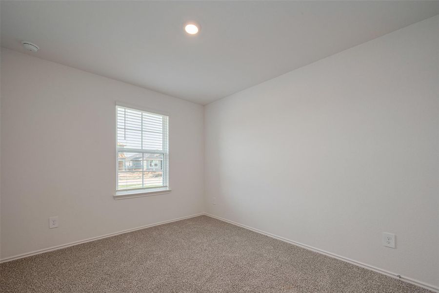 This spacious bedroom is carpeted and filled with daylight from a large window, creating a comfortable retreat. This spacious bedroom is carpeted and filled with daylight from a large window, creating a comfortable retreat.