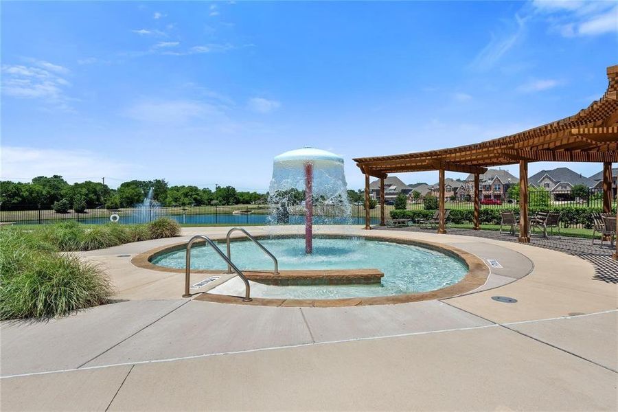 Community pool with a pergola, a patio, a water view, and view of wooded area Community pool with a pergola, a patio, a water view, and view of wooded area
