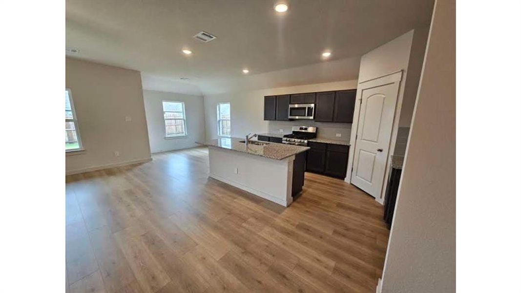 Open-concept living area featuring wood-finish flooring Open-concept living area featuring wood-finish flooring