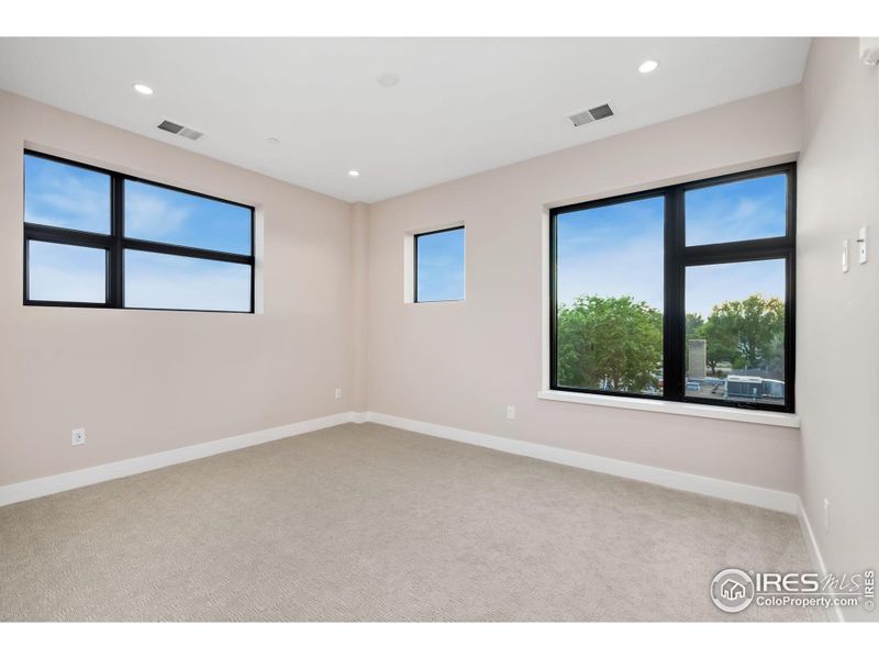 This secondary bedroom is at the top of the south/west side of the building and the smallest of its three windows frames the back range peaks like a commissioned painting.