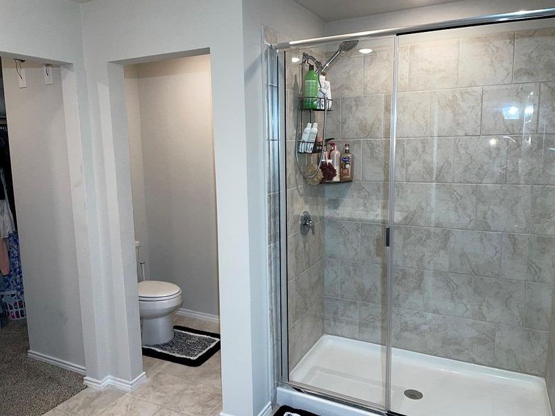 Bathroom with a shower stall and light tile patterned flooring