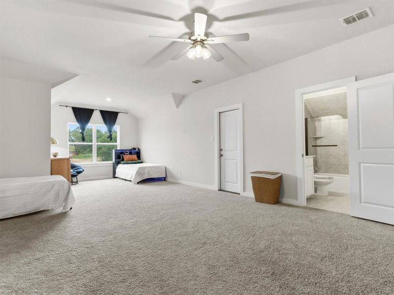 Versatile bonus room upstairs with en-suite bathroom, perfect for large second primary, media room, game room, or additional living space.