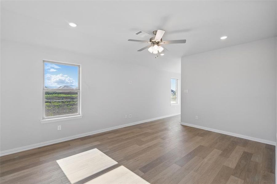 Empty room with wood finished floors, a ceiling fan, and recessed lighting Empty room with wood finished floors, a ceiling fan, and recessed lighting