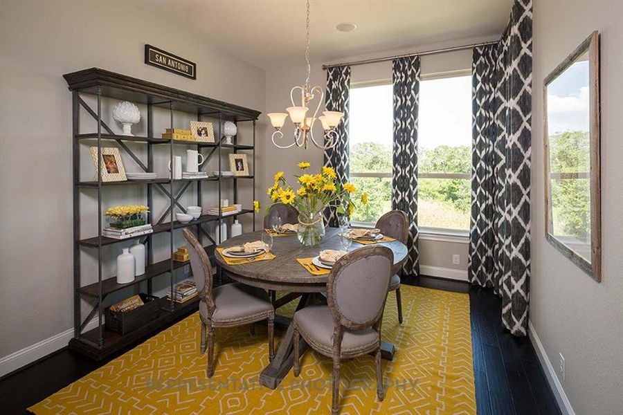 Dining room featuring a chandelier and dark wood-type flooring Dining room featuring a chandelier and dark wood-type flooring
