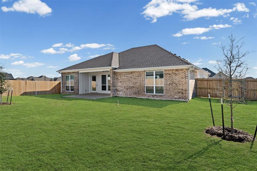 Back of house with brick siding, a fenced backyard, roof with shingles, and a patio area Back of house with brick siding, a fenced backyard, roof with shingles, and a patio area