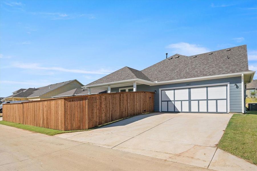 Backview of home with 2 car garage and fenced yard.