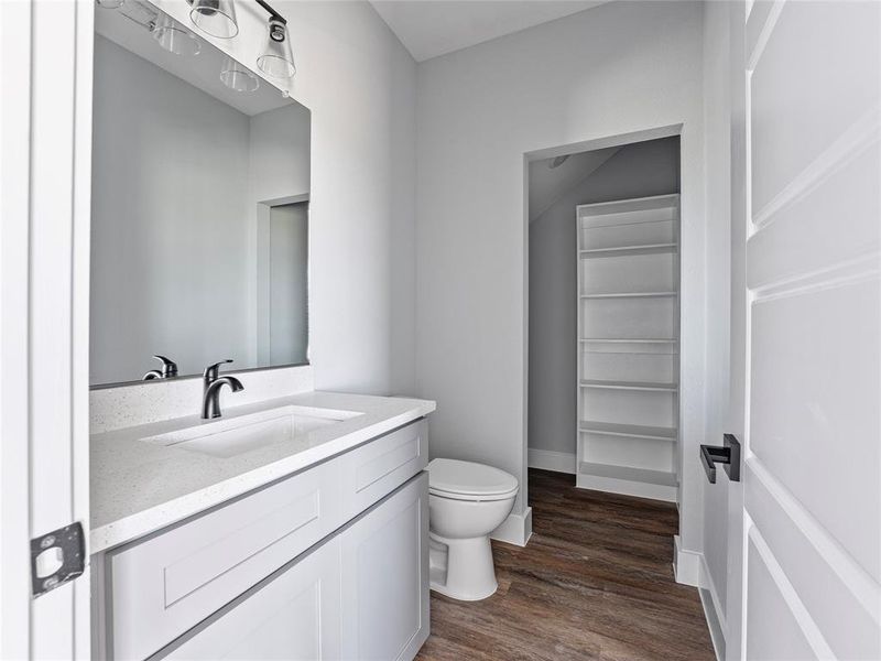 Bathroom featuring toilet, wood finished floors, and vanity