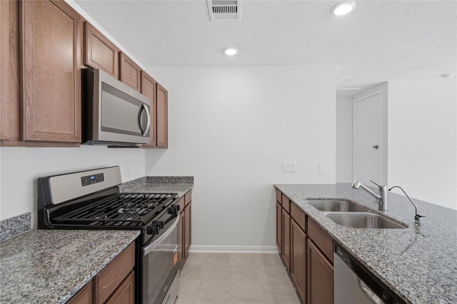 This spacious kitchen has it all—ample storage, generous counter space, and a layout that truly makes it the heart of the home.