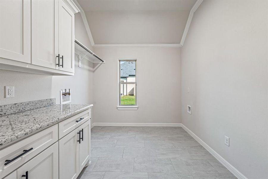 Laundry area featuring ornamental molding, washer hookup, and cabinet space