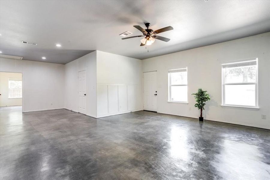 Spacious interior featuring a ceiling fan, recessed lighting, and polished concrete flooring