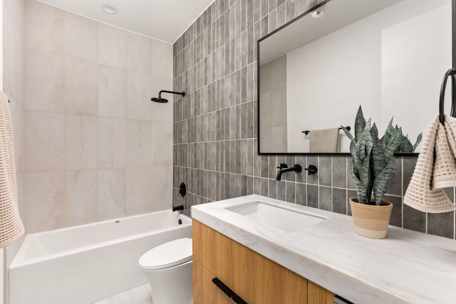 Full bathroom with tile walls, vanity, shower / bath combination with curtain, and backsplash