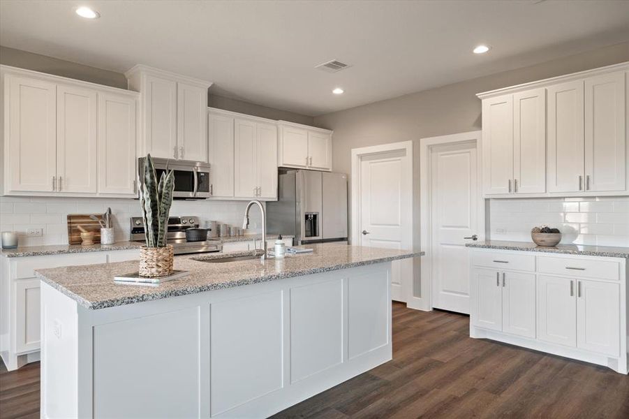 Kitchen featuring white cabinets, dark wood-type flooring, and appliances with stainless steel finishes Kitchen featuring white cabinets, dark wood-type flooring, and appliances with stainless steel finishes