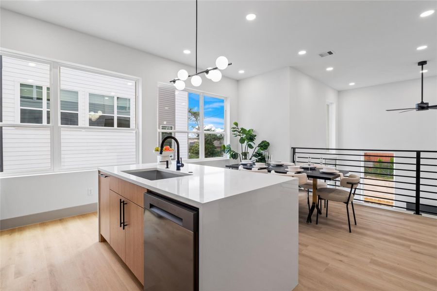 Framed by walls of windows and modern horizontal railings, this elevated kitchen and dining space invites natural light to pour in—highlighting the crisp quartz countertops, sleek matte black fixtures, and seamless indoor-outdoor flow. It's a setting designed for connection, conversation, and everyday luxury. Framed by walls of windows and modern horizontal railings, this elevated kitchen and dining space invites natural light to pour in—highlighting the crisp quartz countertops, sleek matte black fixtures, and seamless indoor-outdoor flow. It's a setting designed for connection, conversation, and everyday luxury.