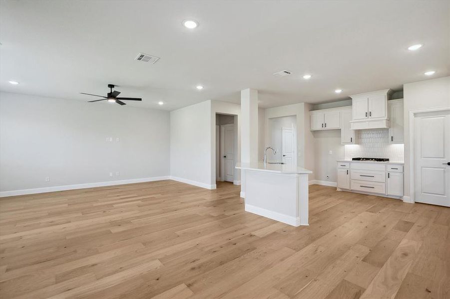 Kitchen featuring ceiling fan, light countertops, recessed lighting, light wood-style floors, and a sink