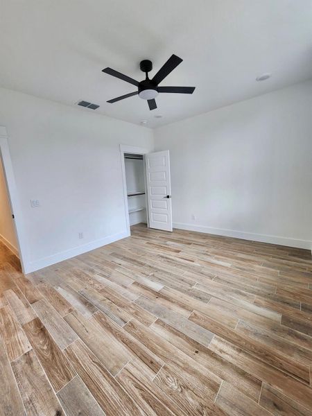 Unfurnished bedroom featuring light wood-style flooring and a ceiling fan