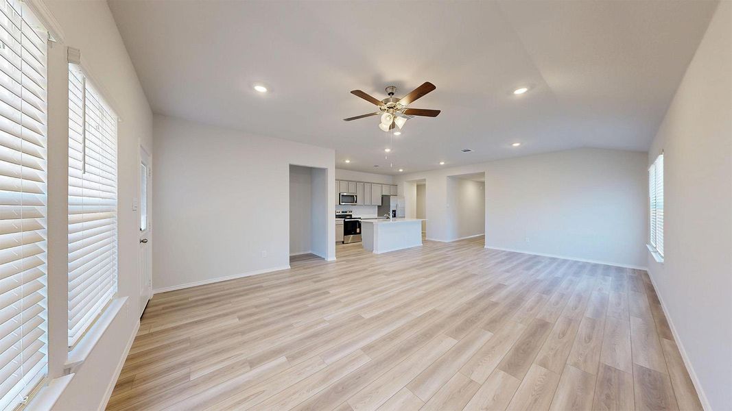 Bright living space featuring wood-finish flooring, recessed lighting, and a ceiling fan