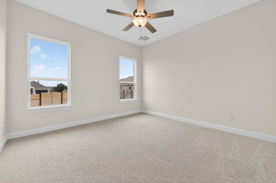 Spare room featuring light carpet and ceiling fan