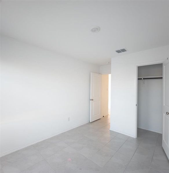 Unfurnished bedroom featuring a closet and light tile patterned flooring