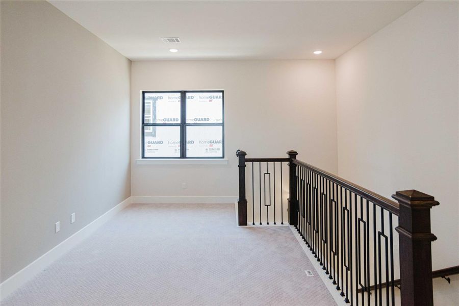 Hallway featuring light carpet, an upstairs landing, and recessed lighting