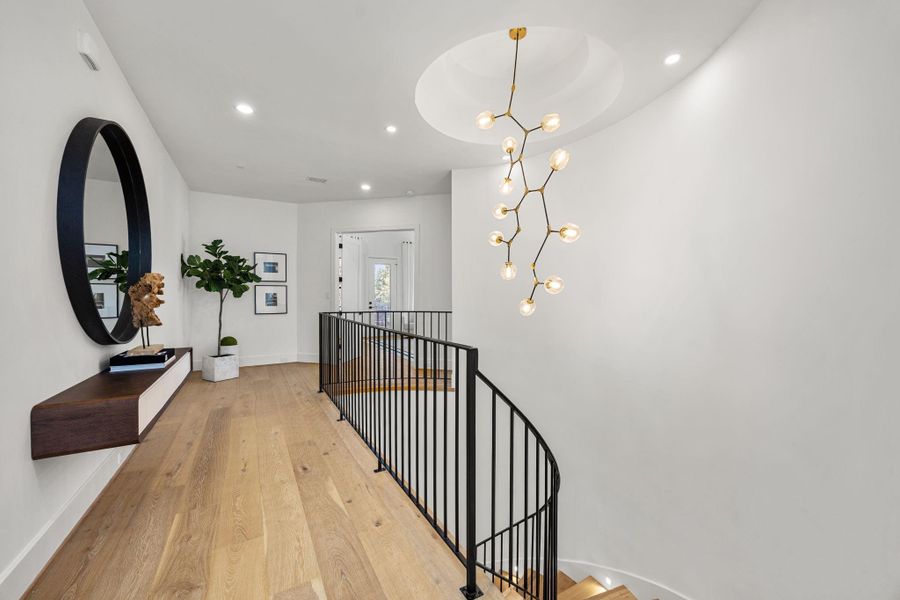 Top of the staircase w/ rotunda & luxury chandelier leading to the Primary Suite, Game Room & other secondary bedrooms. Top of the staircase w/ rotunda & luxury chandelier leading to the Primary Suite, Game Room & other secondary bedrooms.