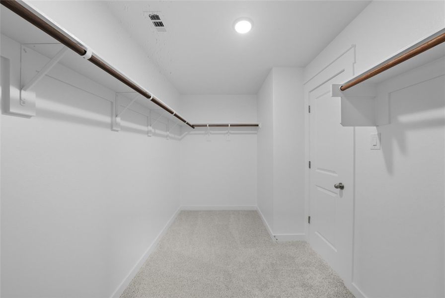 Spacious closet with light colored carpet