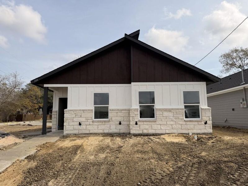 View of side of property with board and batten siding, stone siding, and a porch View of side of property with board and batten siding, stone siding, and a porch